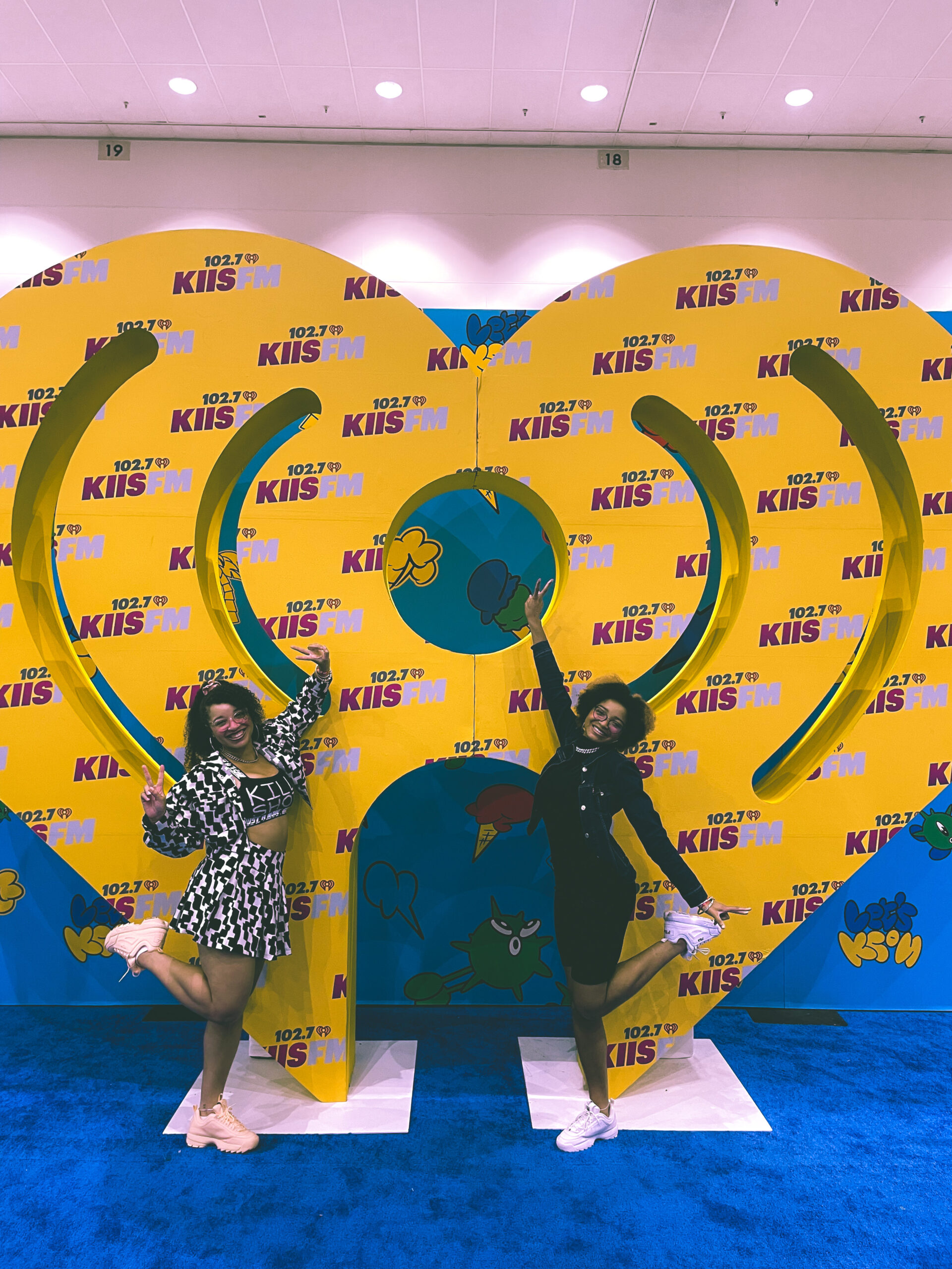 Sisters in coordinated concert outfits making a heart at a korean convention and k-pop concert called K-Con